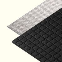 Absorbent dish drying mat holding clean plates, cups, and utensils